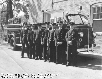 Members of the Cherrydale VFD pose in front of an American LaFrance engine which ran from the Cherrydale station. The firefighter on the left is Sam Felzter and the firefighter second from the right is Marvin Binns, who still serves the CVFD as its president, over thirty years after this picture was taken.
